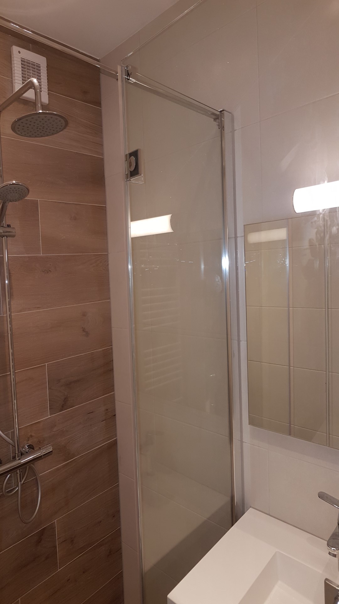 Glazen inloopdouche en wastafel in de gerenoveerde badkamer