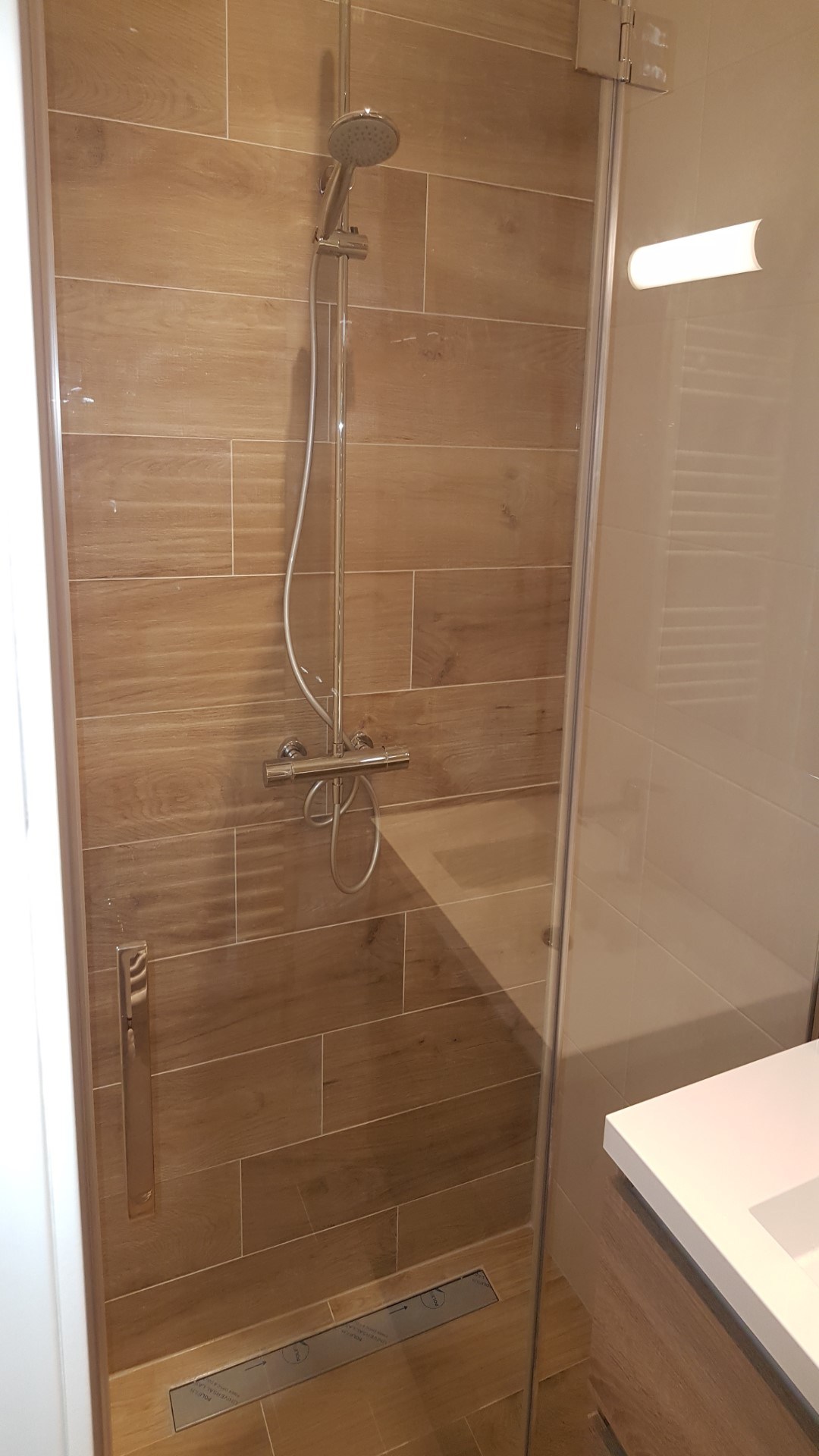 Inloopdouche met houtlook tegelwerk en glazen wand