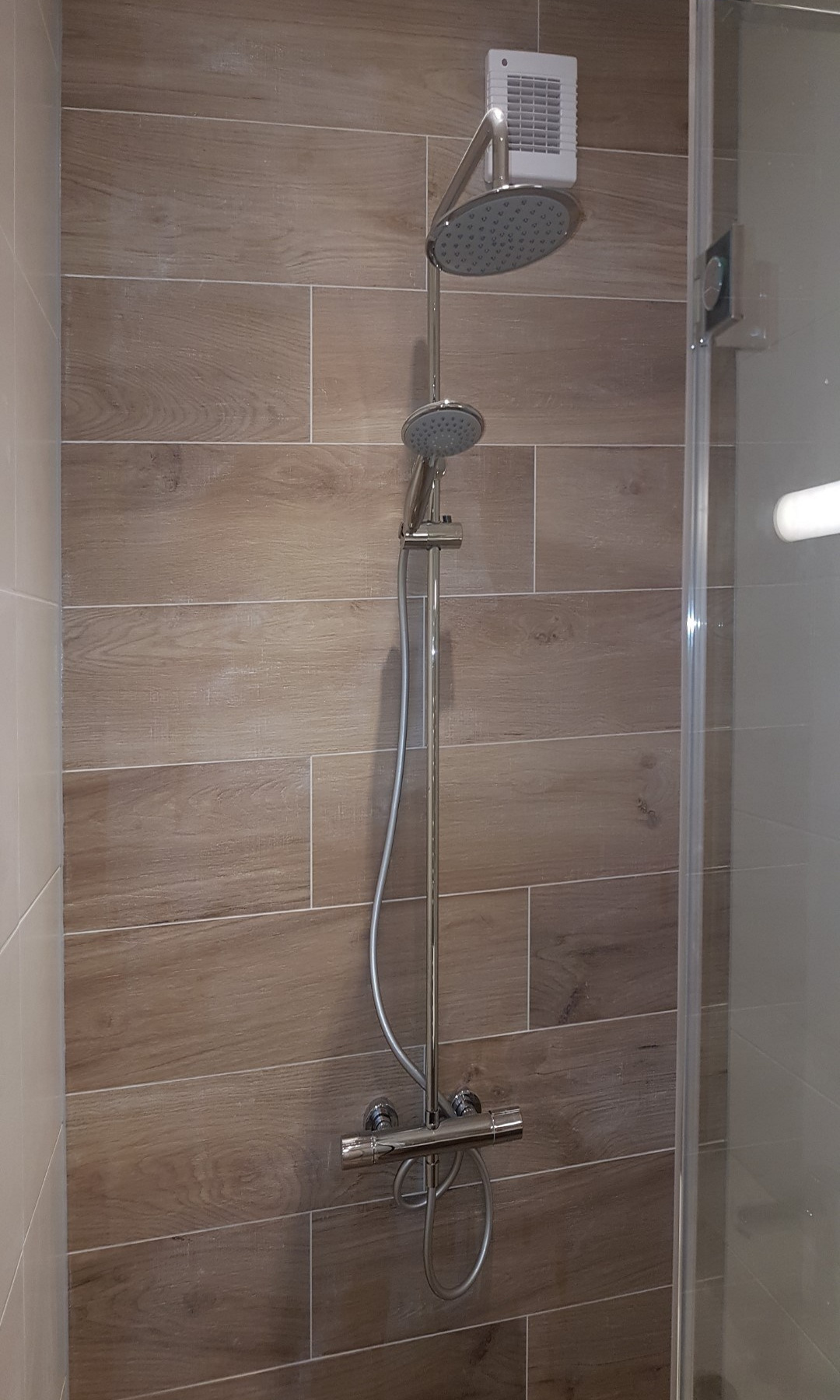 Regen- en handdouche tegen de betegelde wand