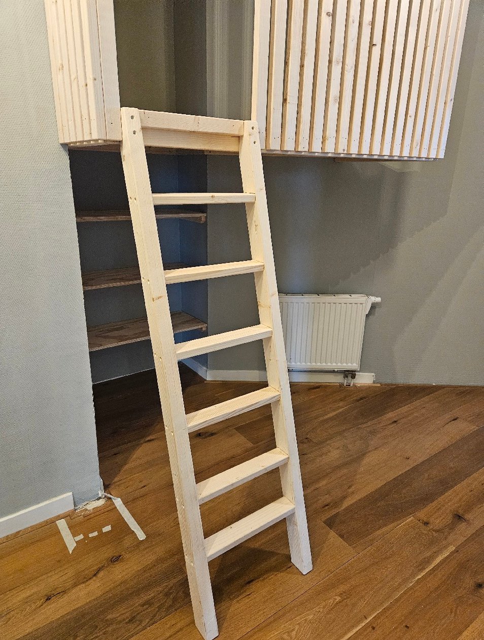 Ladder en opbergruimte onder de maatwerk hoogslaper