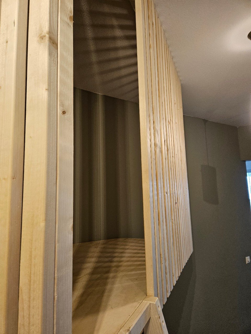 Detail van de houten lattenwand tijdens de montage